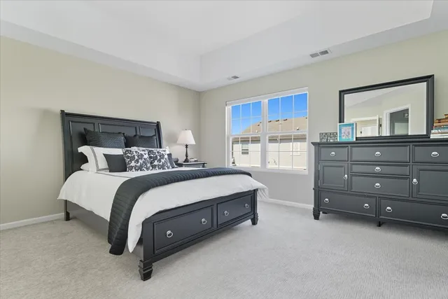 a spacious bedroom with a bed and a dresser