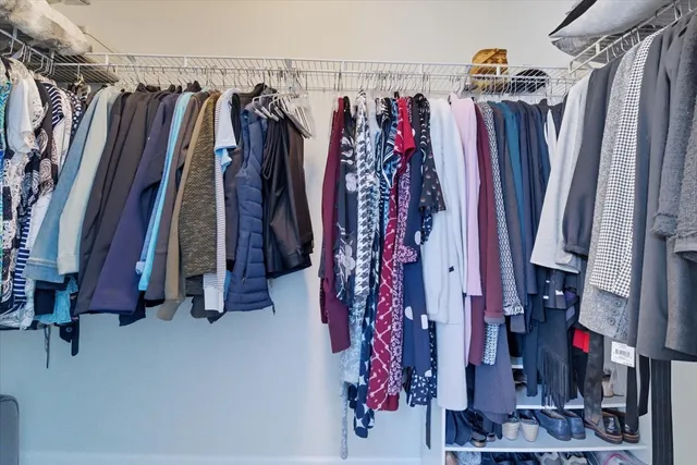 a view of walk in closet with clothes