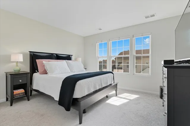 a bed sitting in a bedroom next to a window