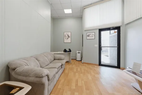 a bedroom with a bed a couch and a large window