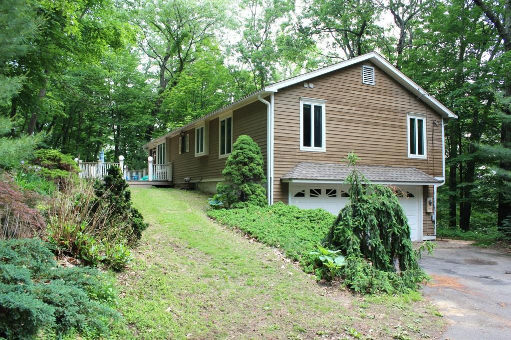 a front view of a house with a yard and trees