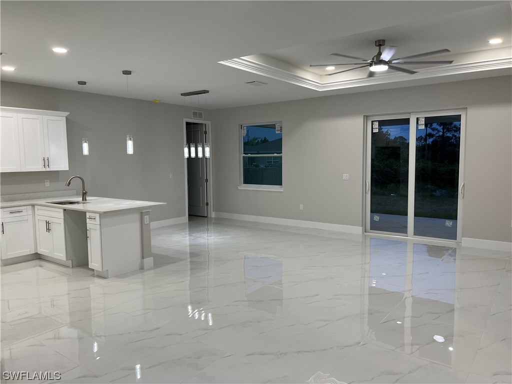 2612 16th Street West Lehigh Acres, FL 33971 - Photo 8 of 25 a view of an empty room with kitchen and chandelier