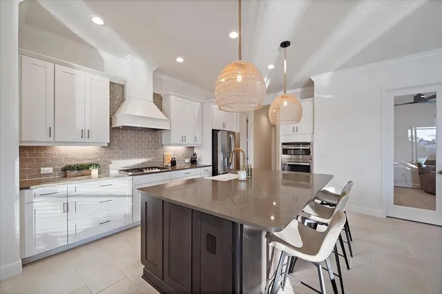 a kitchen with kitchen island white cabinets and stainless steel appliances