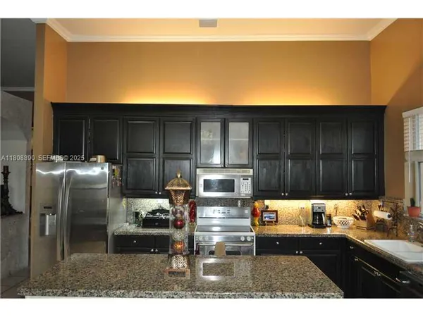 a kitchen with granite countertop a sink cabinets and utility room