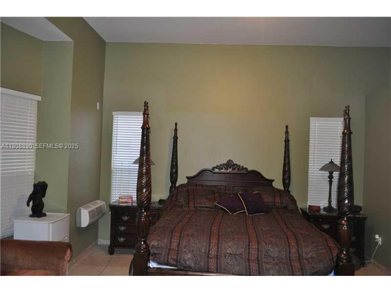 3985 Southwest 152nd Avenue Miramar, FL 33027 - Photo 20 of 26 a bed sitting in a bedroom next to a window