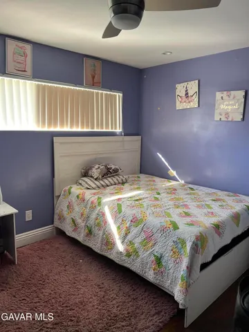 a bedroom with a bed and painting on the wall