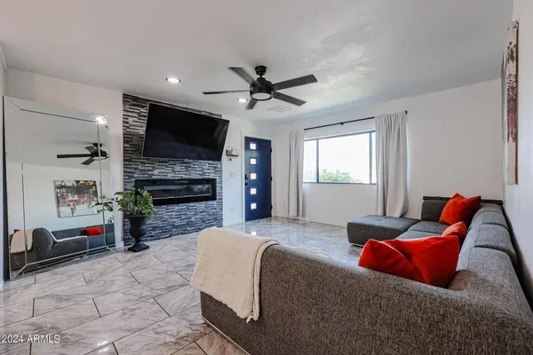 a living room with furniture a flat screen tv and a fireplace
