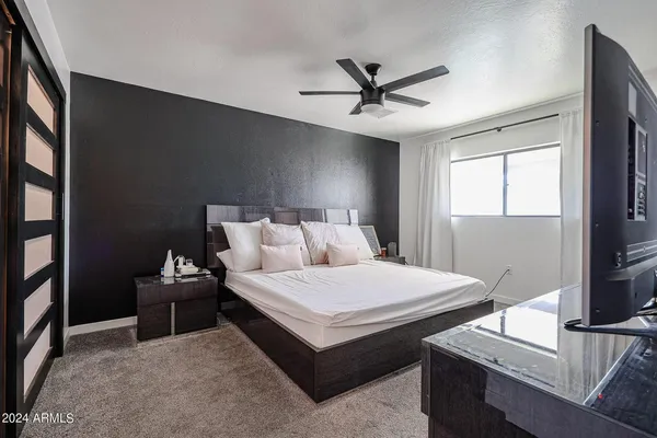 a bedroom with a bed and a flat screen tv