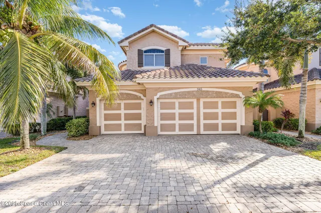 a view of a house with a yard and large tree