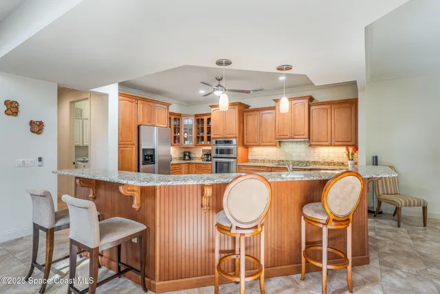 a kitchen with stainless steel appliances granite countertop a kitchen island a table and chairs