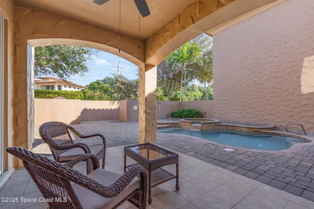 a view of a white house with a fountain plants and palm tree