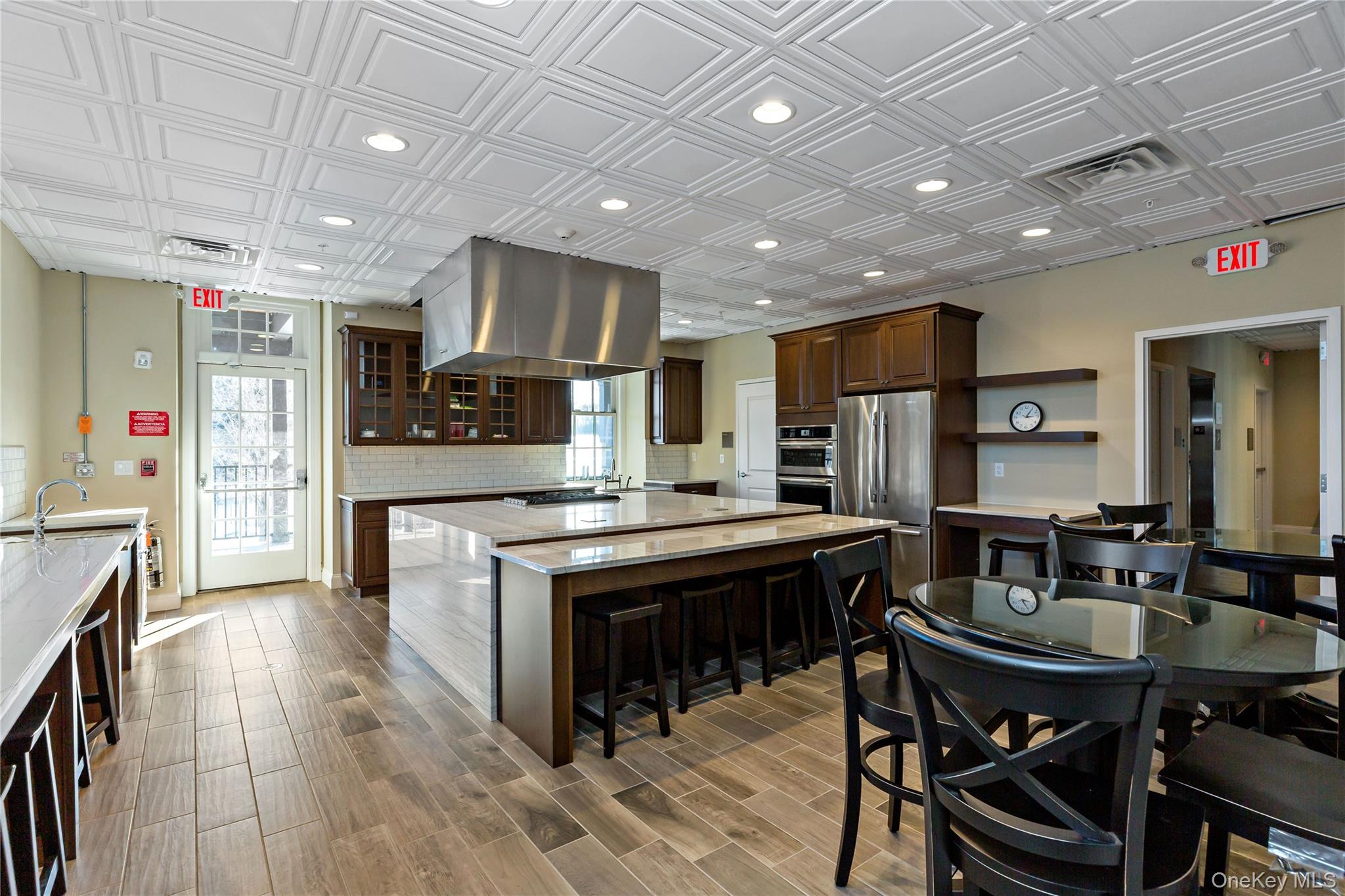 341 Furnace Dock Road, Unit 5 Cortlandt Manor, NY 10567 - Photo 33 of 41 a kitchen with stainless steel appliances kitchen island granite countertop a table chairs and a refrigerator