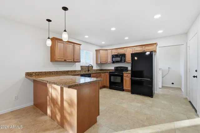 a kitchen with stainless steel appliances granite countertop a refrigerator a sink and a stove
