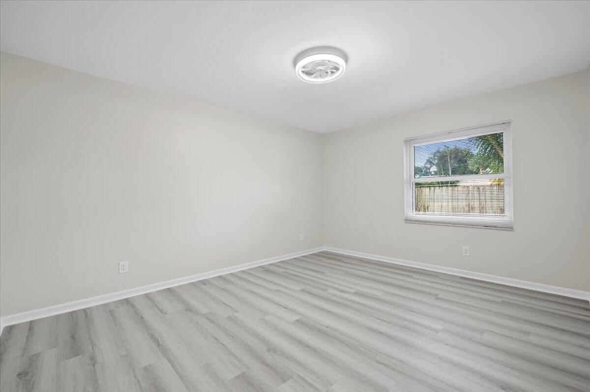 196 Raintree Trail Jupiter, FL 33458 - Photo 13 of 28 a view of an empty room with wooden floor and a window
