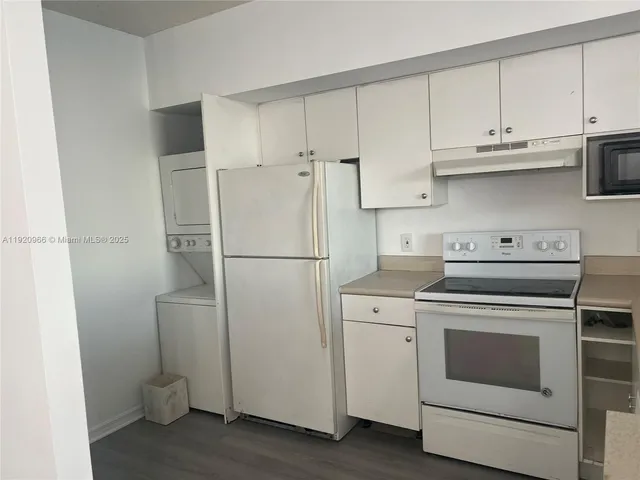 a kitchen with a refrigerator sink stove and cabinets