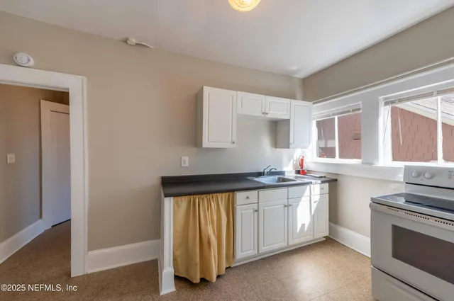 a kitchen with a sink stove and cabinets