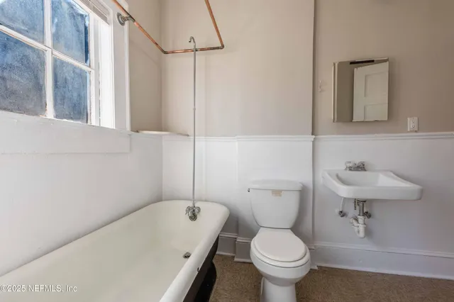 a bathroom with a toilet sink and mirror