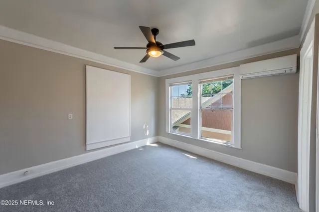 an empty room with windows and ceiling fan