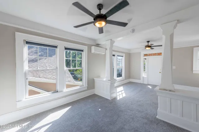 a view of an empty room with a window and a ceiling fan