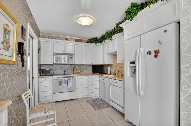 a kitchen with white cabinets and white appliances