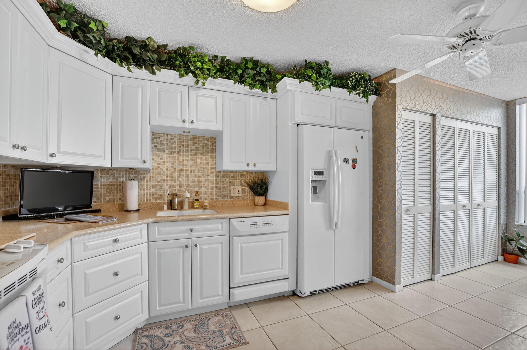 7178 Promenade Drive, Unit 502 Boca Raton, FL 33433 - Photo 15 of 33 a kitchen with white cabinets and refrigerator