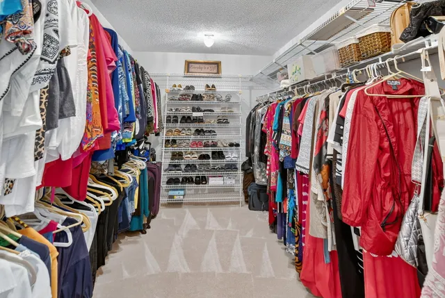 a view of walk in closet with clothes