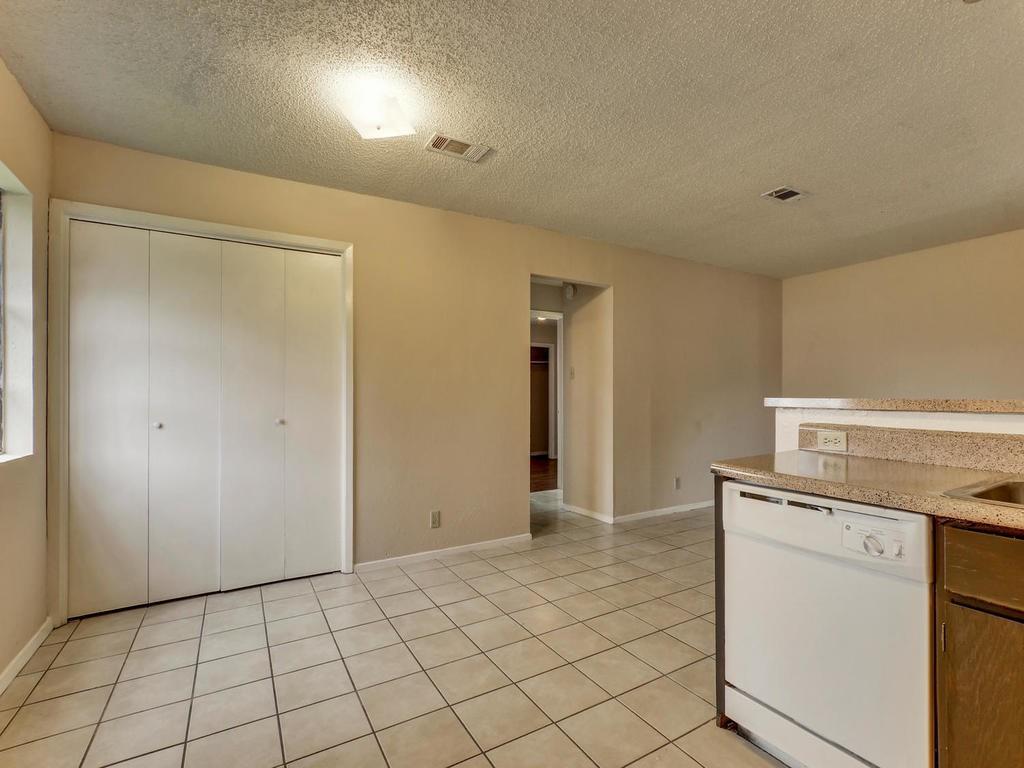 4300 Acropolis Court, Unit A Austin, TX 78759 - Photo 6 of 14 Kitchen featuring white dishwasher, a textured ceiling, light stone counters, and light tile patterned flooring