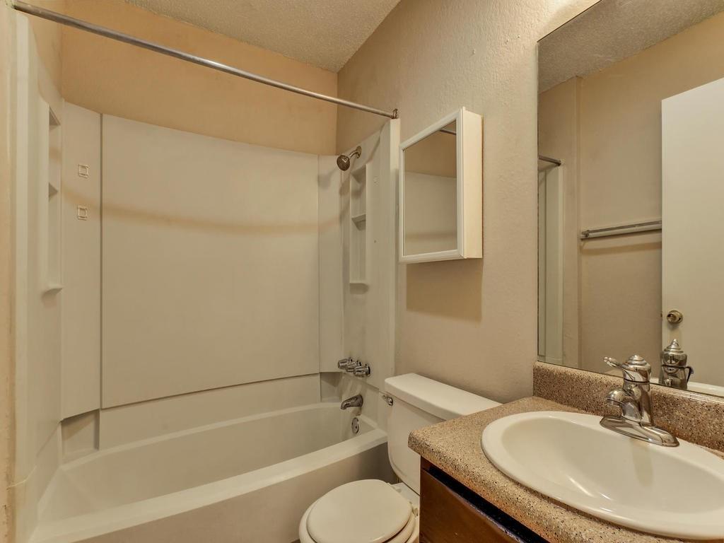 4300 Acropolis Court, Unit A Austin, TX 78759 - Photo 7 of 14 Bathroom with vanity, a textured ceiling, and washtub / shower combination