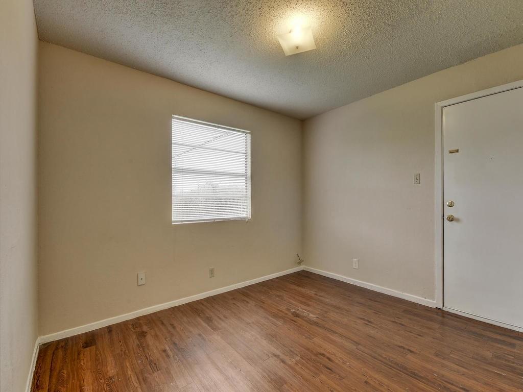 4300 Acropolis Court, Unit A Austin, TX 78759 - Photo 9 of 14 Spare room with a textured ceiling and dark wood-type flooring