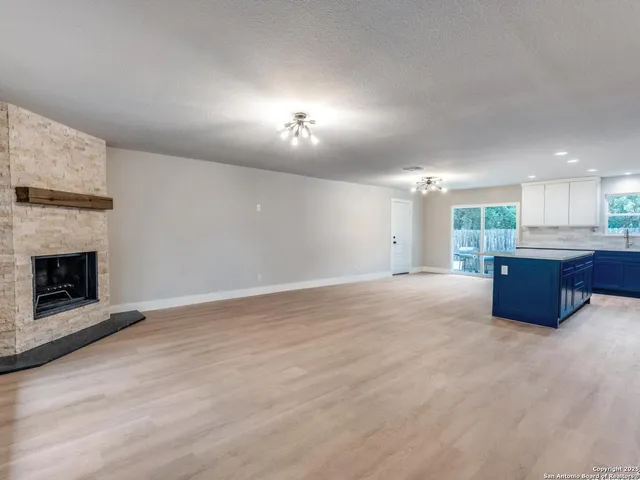 a kitchen with kitchen island a stove a sink a refrigerator and cabinets