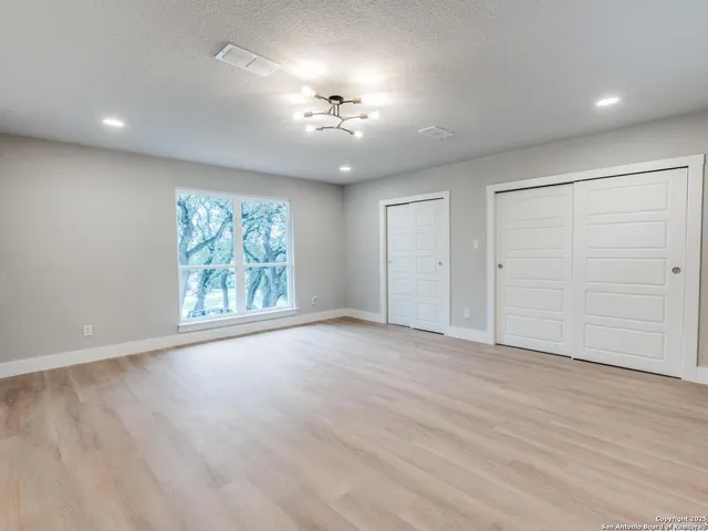 an empty room with windows and cabinet