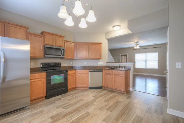 a kitchen with a refrigerator stove top oven and sink
