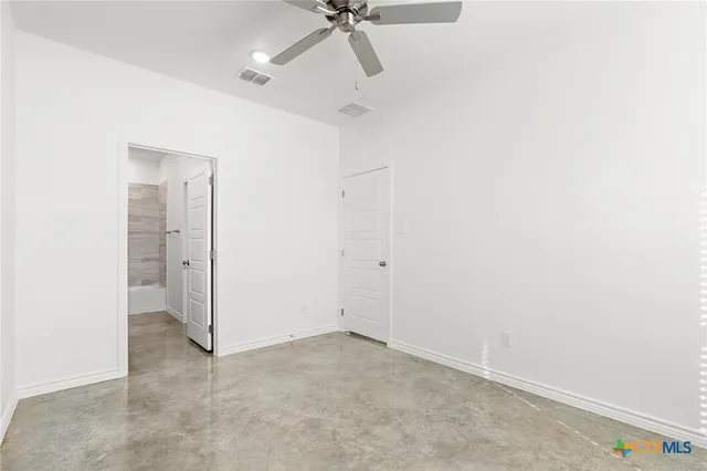 a view of a room with a ceiling fan and a window