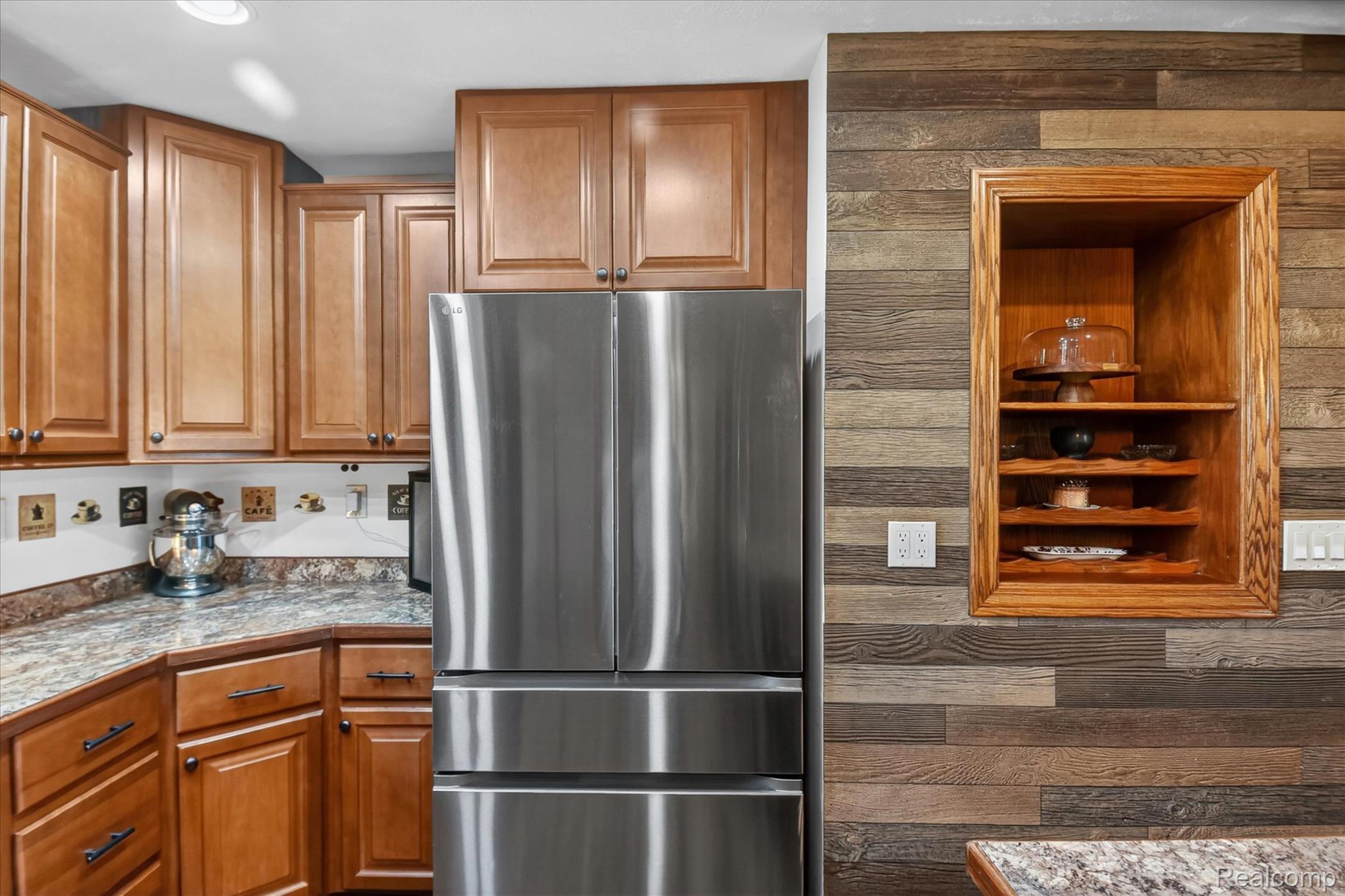 3949 West Burns Line Road Brown City, MI 48416 - Photo 20 of 70 Kitchen featuring abundant cabinetry with wood-finish doors, stainless steel refrigerator, and a recessed wooden display niche