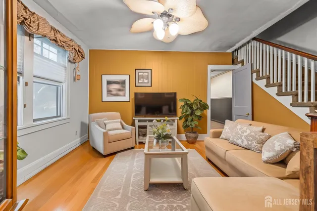 a living room with furniture chandelier and a flat screen tv