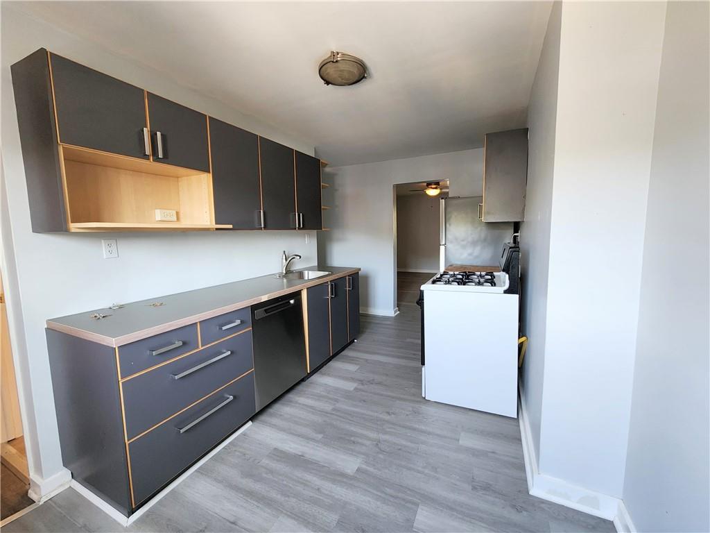 5237 Butler Street, Unit 2 Pittsburgh, PA 15201 - Photo 2 of 6 a kitchen with stainless steel appliances a stove microwave and cabinets