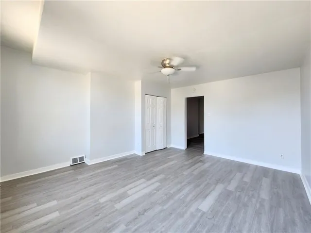 a view of an empty room with wooden floor