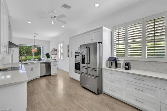 a kitchen with white cabinets and stainless steel appliances