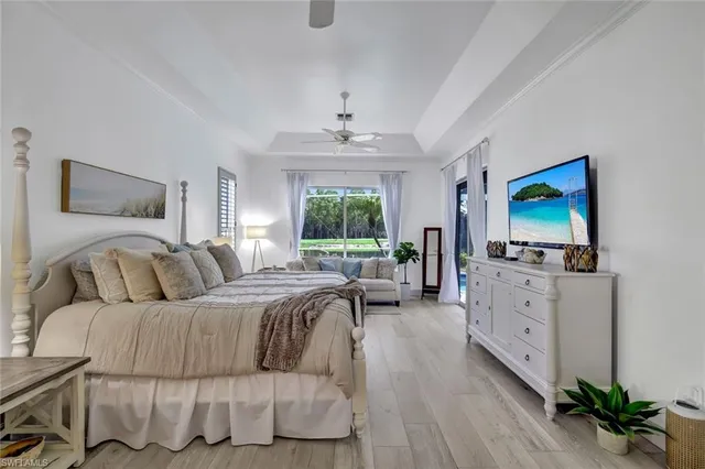 a bedroom with a large bed and a flat tv screen on dresser