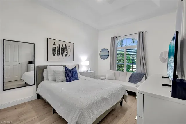 a bedroom with a bed a window and a flat screen television