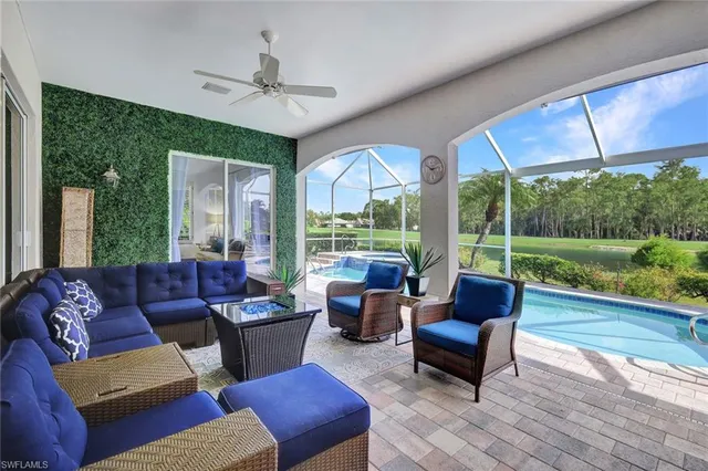 a living room with furniture and a floor to ceiling window