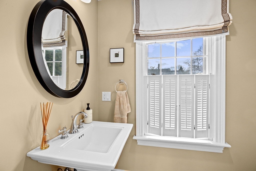 50 Pleasant Street Hingham, MA 02043 - Photo 14 of 41 a bathroom with a sink a mirror a vanity and a window