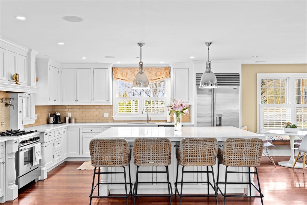 50 Pleasant Street Hingham, MA 02043 - Photo 7 of 41 a kitchen with stainless steel appliances kitchen island granite countertop a stove a sink and white cabinets