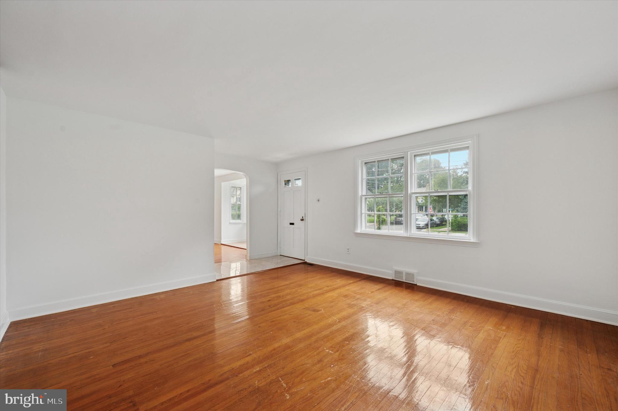 211 East Manoa Road Havertown, PA 19083 - Photo 3 of 29 an empty room with wooden floor and windows