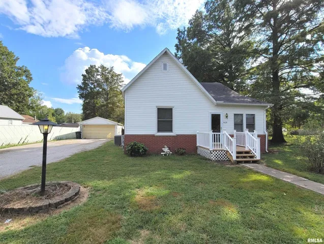 a view of a house with a yard and a tree