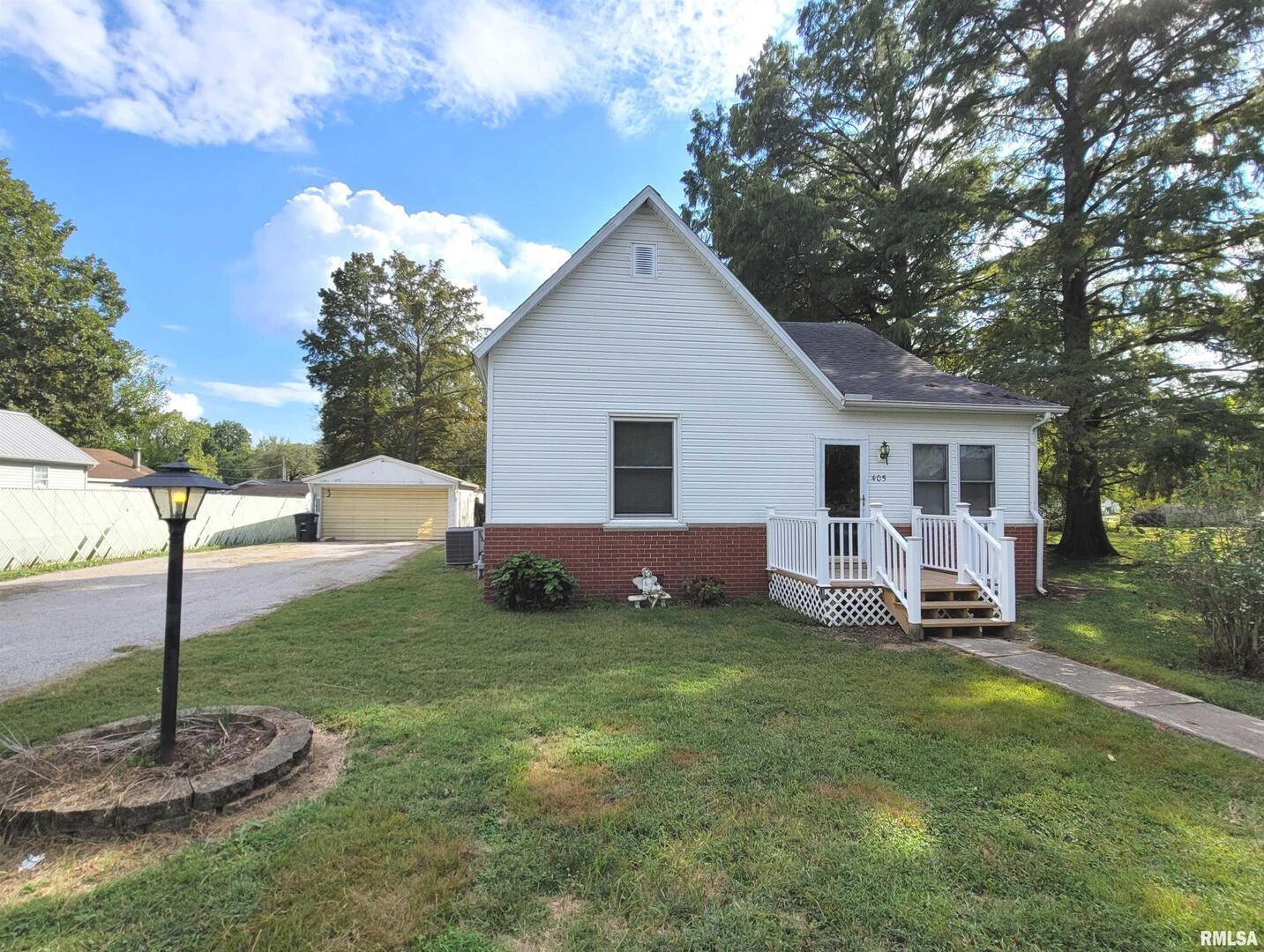 a view of a house with a yard and a tree