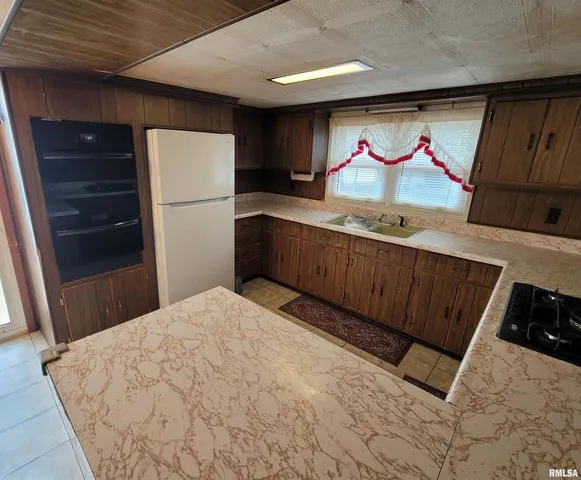 a view of a refrigerator in kitchen and wooden floor