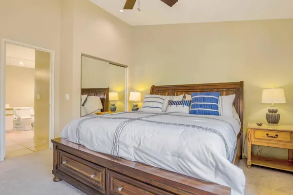 a bedroom with a bed and a lamp on dresser