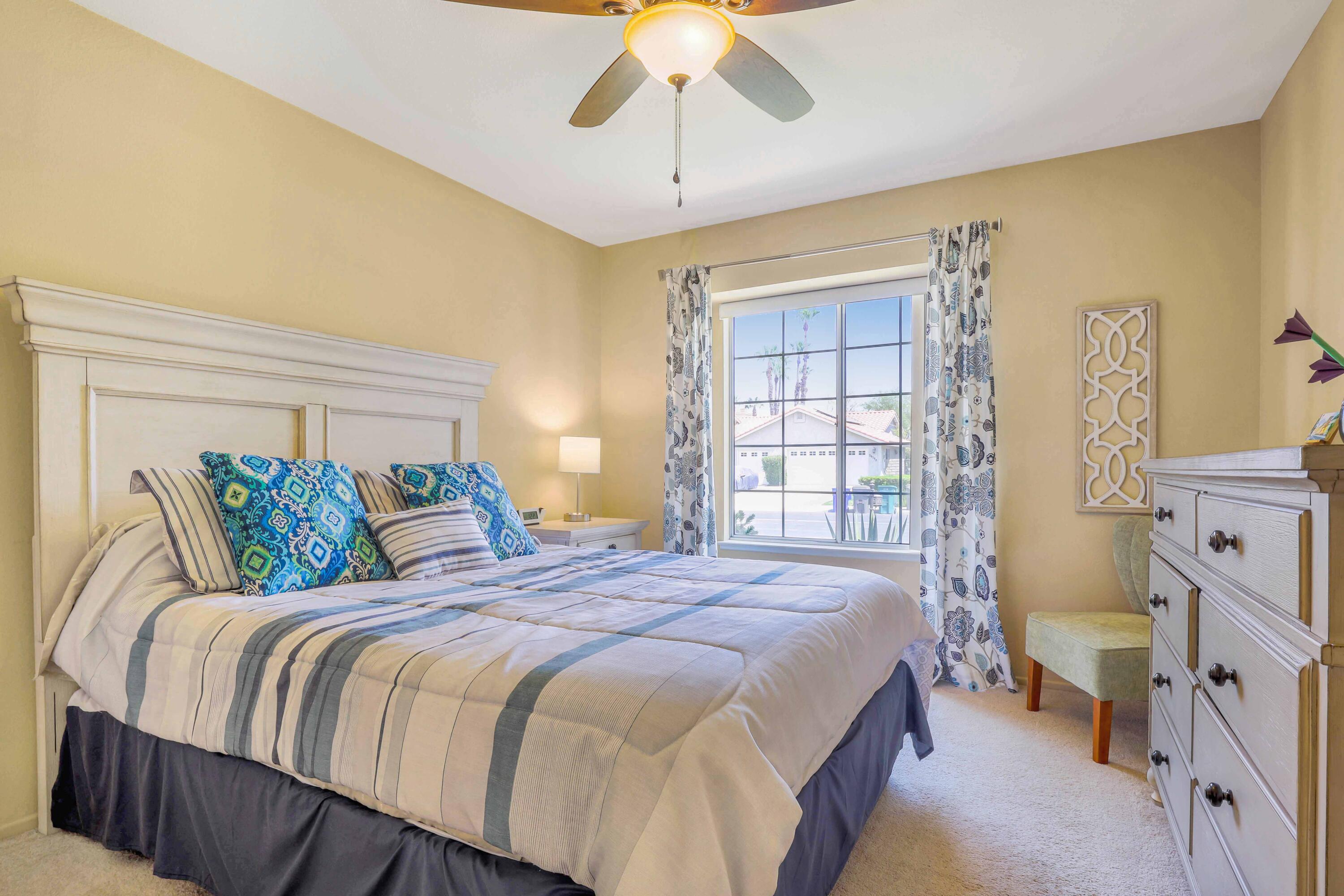 39795 Regency Way Palm Desert, CA 92211 - Photo 16 of 25 a bedroom with a bed and a chandelier