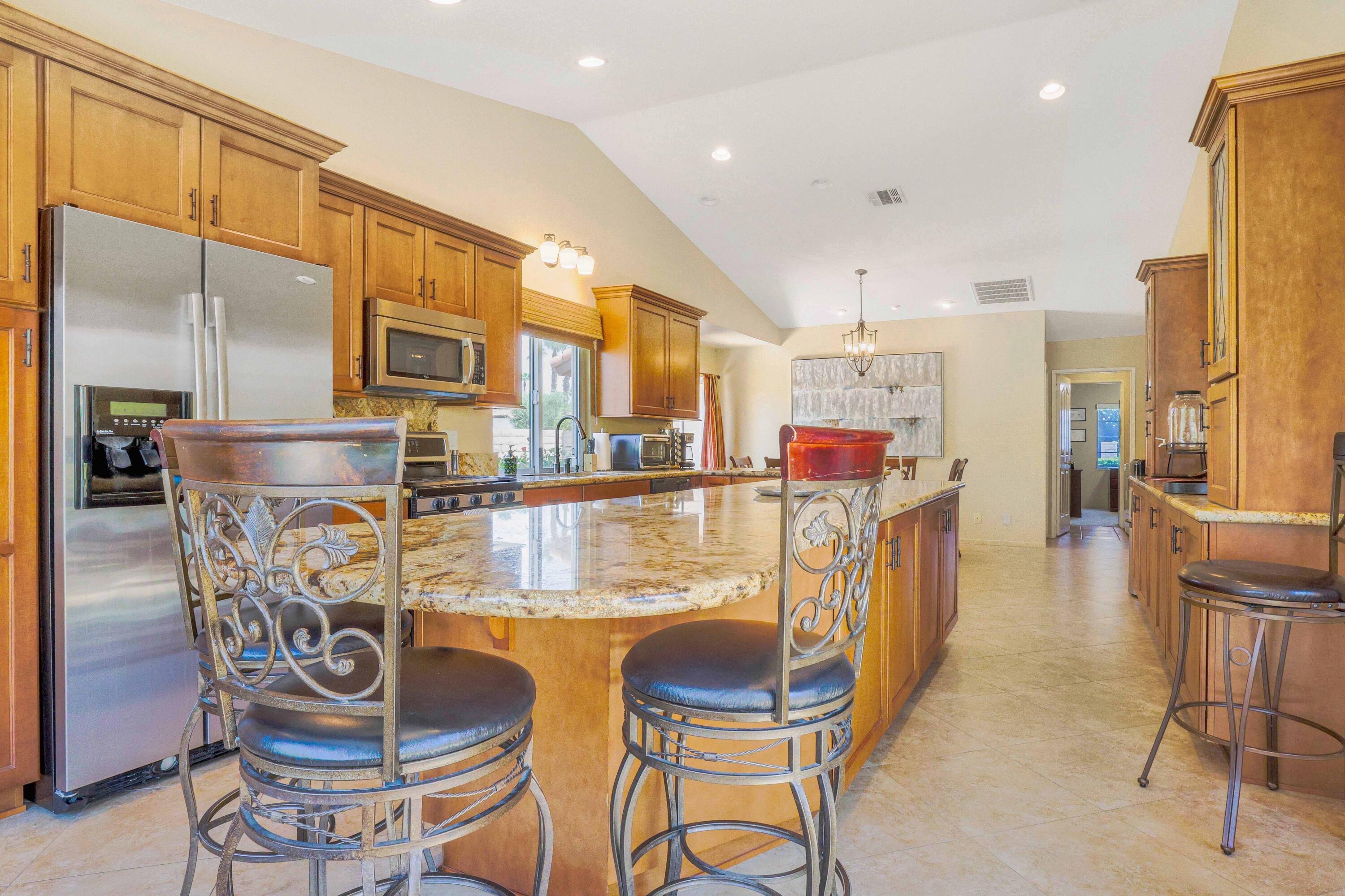39795 Regency Way Palm Desert, CA 92211 - Photo 8 of 25 a kitchen with stainless steel appliances kitchen island granite countertop a table and chairs